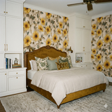 Floral pattern wallpaper with sunflower design from Heliora, covering the walls of a bedroom.