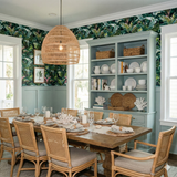 Tropical foliage wallpaper with banana leaves and greenery, covering the walls above pale green wainscoting.