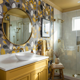 Amberleaf Study Wallpaper with leaf pattern by an unspecified brand, covering bathroom wall behind round mirror and vanity.
