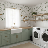 Green leaf patterned wallpaper with white and gold accents in a laundry room.