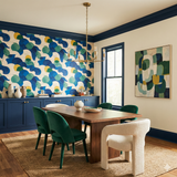 Pacific Pulse Wallpaper with blue, yellow, and green patterns, from York Wallcoverings, covering the upper wall of a dining room.