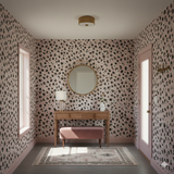 Freya Spot Wallpaper with black and white spots, covering walls in a styled entryway.