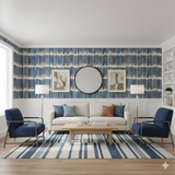 Blue striped wallpaper by Wallshoppe with vertical brushstroke pattern, in a living room setting.
