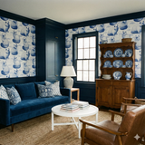 Cloudborne Persians wallpaper featuring a cat pattern on the wall behind a blue sofa.
