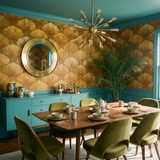 Gold shell patterned wallpaper with a vintage look, adorned with a brass mirror, paired with teal trim and molding.