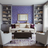 Purple floral wallpaper with a colorful confetti design, featuring a white sofa and matching grey bookshelves.