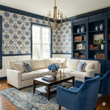 Indigo wallpaper by Linenfolk with a blue floral damask pattern on a neutral background, covering the upper portion of a traditional-style living room.