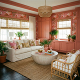 Flamingo-patterned wallpaper by Katie Kime, with coral trim, bamboo blinds, and abundant tropical plants.
