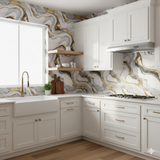 Aurielle Veins Wallpaper with swirling patterns of gray, white, and gold, covering the wall.