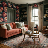 Caldermere Wallpaper with a floral pattern, covering the walls above a salmon velvet sofa and decorative area rug.