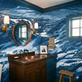 Blue scenic wallpaper with a snowy mountainscape pattern, decorating a modern bathroom.
