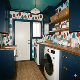 Leaf pattern wallpaper with indigo trim, in a laundry room with butcher block countertop and white front load washer.