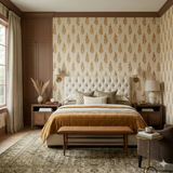Aurelian Sheaf wallpaper in earth tones with a leaf pattern, styled as an accent wall in a bedroom.
