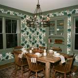 Green Everpine Assembly wallpaper with pinecone pattern, covering the walls of a dining room.
