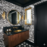 Bayou City Blueprint Wallpaper with black and white cityscape drawing, covering the walls in a bathroom with gold accents.