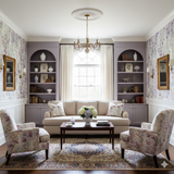 Floral print Orchidée Lune Wallpaper with purple accents, decorating a living room interior.