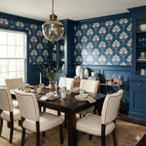 Blue patterned wallpaper from Fieldhouse, paired with blue wainscoting in a dining room setting.