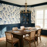 Bluewind Meadow Wallpaper with blue floral pattern, displayed in a dining room above blue wainscoting.