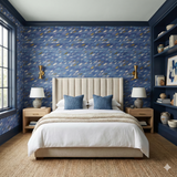 Zephyr Drift Wallpaper with blue, white, and gold pattern, styled in a bedroom with a bed and nightstands.
