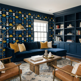 Floral folk wallpaper with blue background by Marin, featuring yellow and white flower pattern, in a styled room setting.