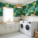 Green tropical leaf pattern wallpaper by Wallshoppe, shown with white cabinets and a farmhouse sink.