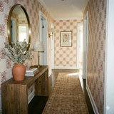 Floral rosette field wallpaper with copper pattern on beige background, decorating a hallway.