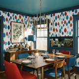 Leaf pattern wallpaper in red, teal and navy blue colors, plus a botanical print on the buffet.