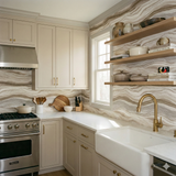 Stoneveil Strata wallpaper with marble wave pattern, decorating a kitchen with wooden shelves and brass faucet.
