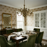 Textured wallpaper with crest pattern, gold on beige, covering the walls of a dining room.
