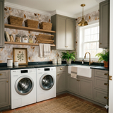 Leaf-patterned wallpaper from Hearthborn, decorating a laundry room with grey cabinetry, woven baskets, and a farmhouse sink.