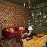 Tulip Arcade Wallpaper featuring red and gold tulip motif over dark background, covering an elegant living room space.
