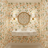 Floral Blush Meadow Wallpaper with botanical print, featuring pink and yellow blooms, covering the entire bathroom wall.

