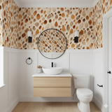 Auburn Quarry Wallpaper featuring earth-toned watercolor pebble pattern on neutral background, decorating a modern bathroom.