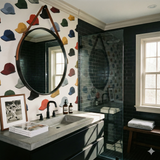 Baseball cap pattern wallpaper with colorful hats, alongside a round mirror.
