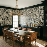 Black and cream Fragment Field Wallpaper with animal print pattern, covering the upper half of a dining room wall.