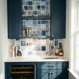 Blue watercolor block wallpaper from Port Azure, decorating a bar area with blue cabinetry and wine cooler.