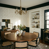 Champagne stipple wallpaper with a delicate polka dot pattern, decorating a dining room with a dark wooden table and chairs.