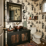 High Noon Revenant Wallpaper featuring desert landscape pattern with cowboys and cactus, shown on the walls of a bathroom.