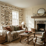 Applegate Acres wallpaper featuring a countryside scene by Brewster, adorning a living room wall with framed botanical prints.