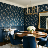 Floral Vera Grace Wallpaper with a navy background and scattered white and tan blossoms, creating a charming and elegant accent wall.

