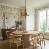 Cascade wallpaper with wavy pattern, by Wovenshore, in neutral earth tones covering a dining room.
