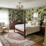 Green Edelweiss Hollow wallpaper with a dog pattern, featuring a dark wood four-poster bed in the foreground.