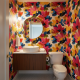 Floral bloom wallpaper with red and blue design, from Atelier Bloom, covering bathroom walls with a bright, colorful pattern.
