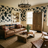 Black and white wallpaper from Oxenveil with a cow-like pattern in a traditional living room setting.