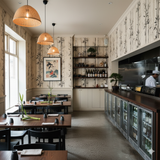 Bamboo patterned wallpaper from Kyoto Reed, decorating a restaurant with dark wood furniture.
