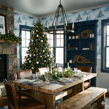 Scenic wallpaper from Seabrook Wallcoverings, depicting snow-covered pine trees on a pale blue backdrop.