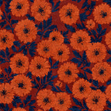Floral field wallpaper with orange flowers by Marona, and dark blue leaves against a rust-red background.