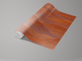 Roll of Canyons wallpaper with abstract painted pattern in orange and brown tones.