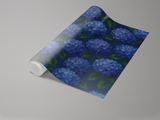 Blue floral wallpaper with hydrangeas pattern, cascading from a roll.
