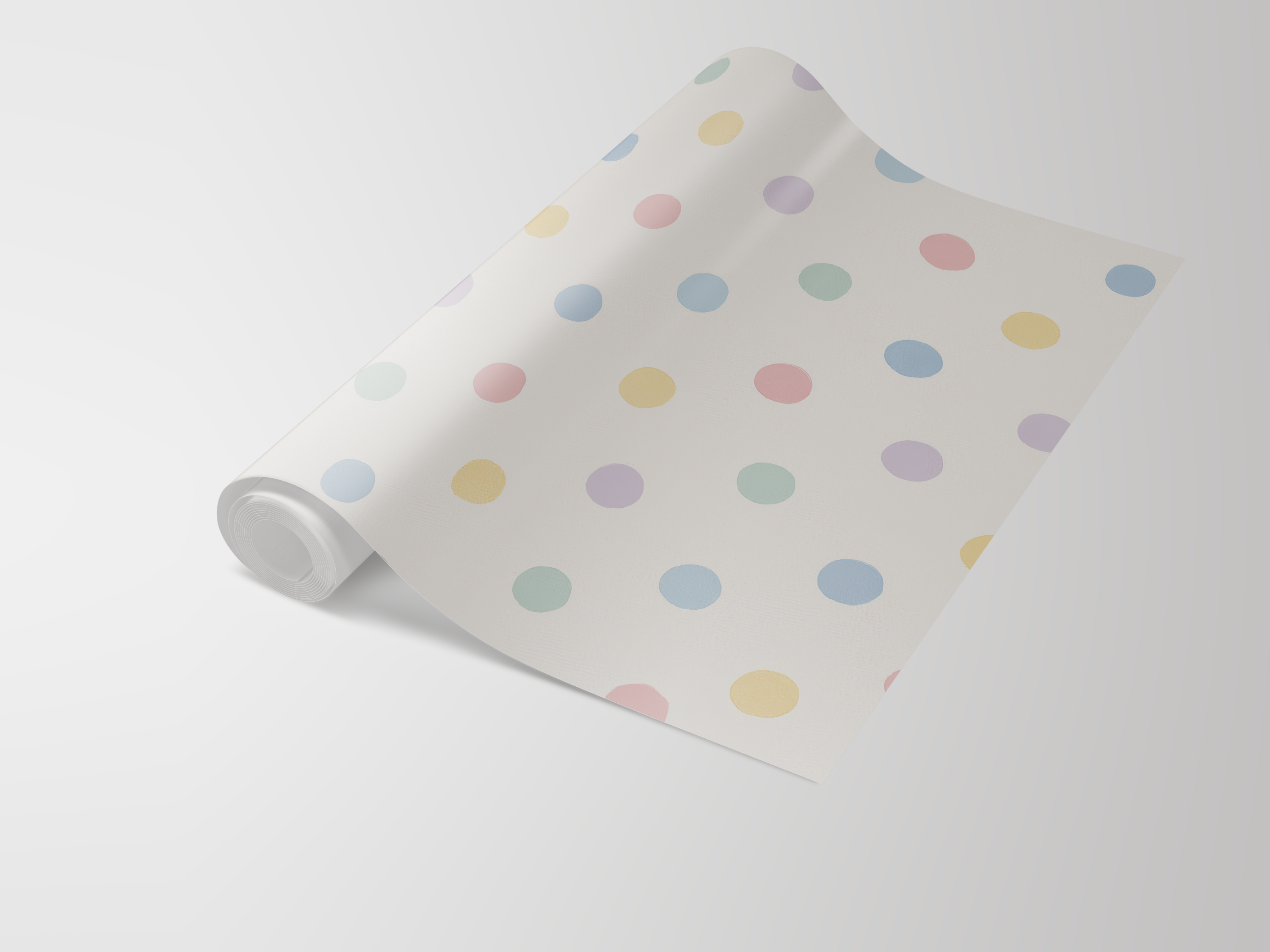 Roll of wallpaper with pastel polka dots on a cream background.